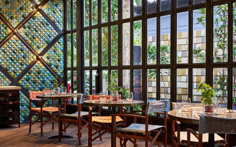 Cafe interior dining area with a green tiled wall and wooden furniture