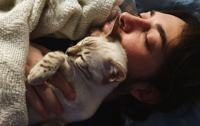 Sleeping cat snuggled in on a man's chest